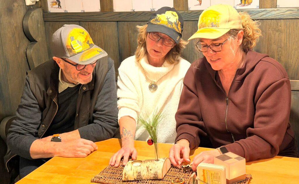 Drei Personen im Tierschutz sitzen zusammen am Tisch und tragen KitzCaps Caps